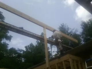 Carpenter setting a ridge beam over a new addition frame — Ice Dam Removal by Roofing Brothers in Little Plymouth