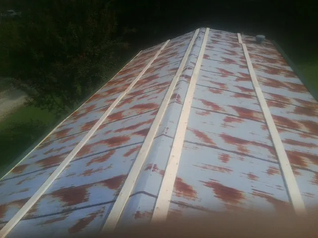 Rusted metal roof panels with new wood purlins before replacement — Storm Damage Roof Repair in Little Plymouth by Roofing Brothers