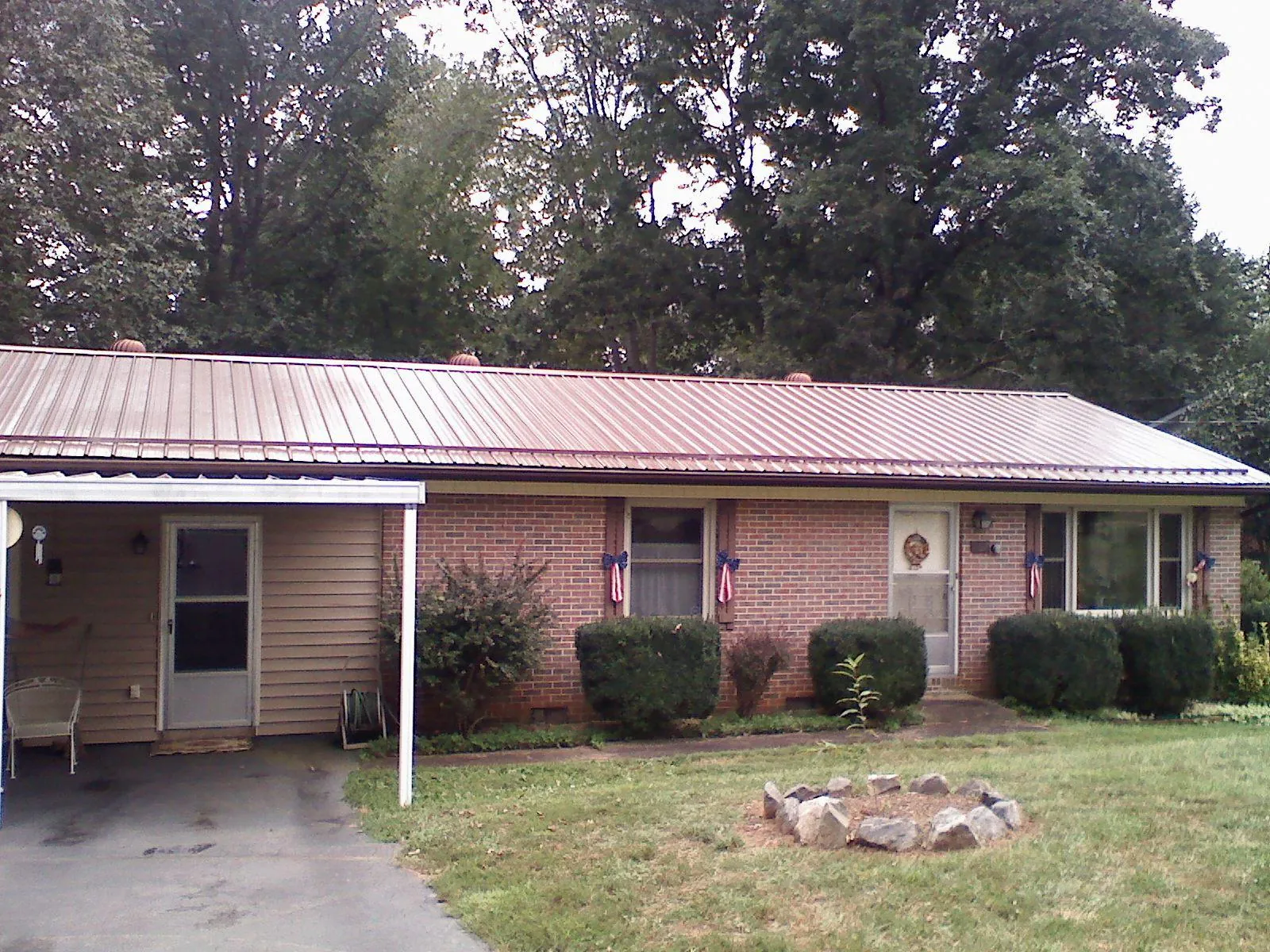 Bronze metal roof and carport on a brick ranch home — Roof Repair work by our crew in Little Plymouth
